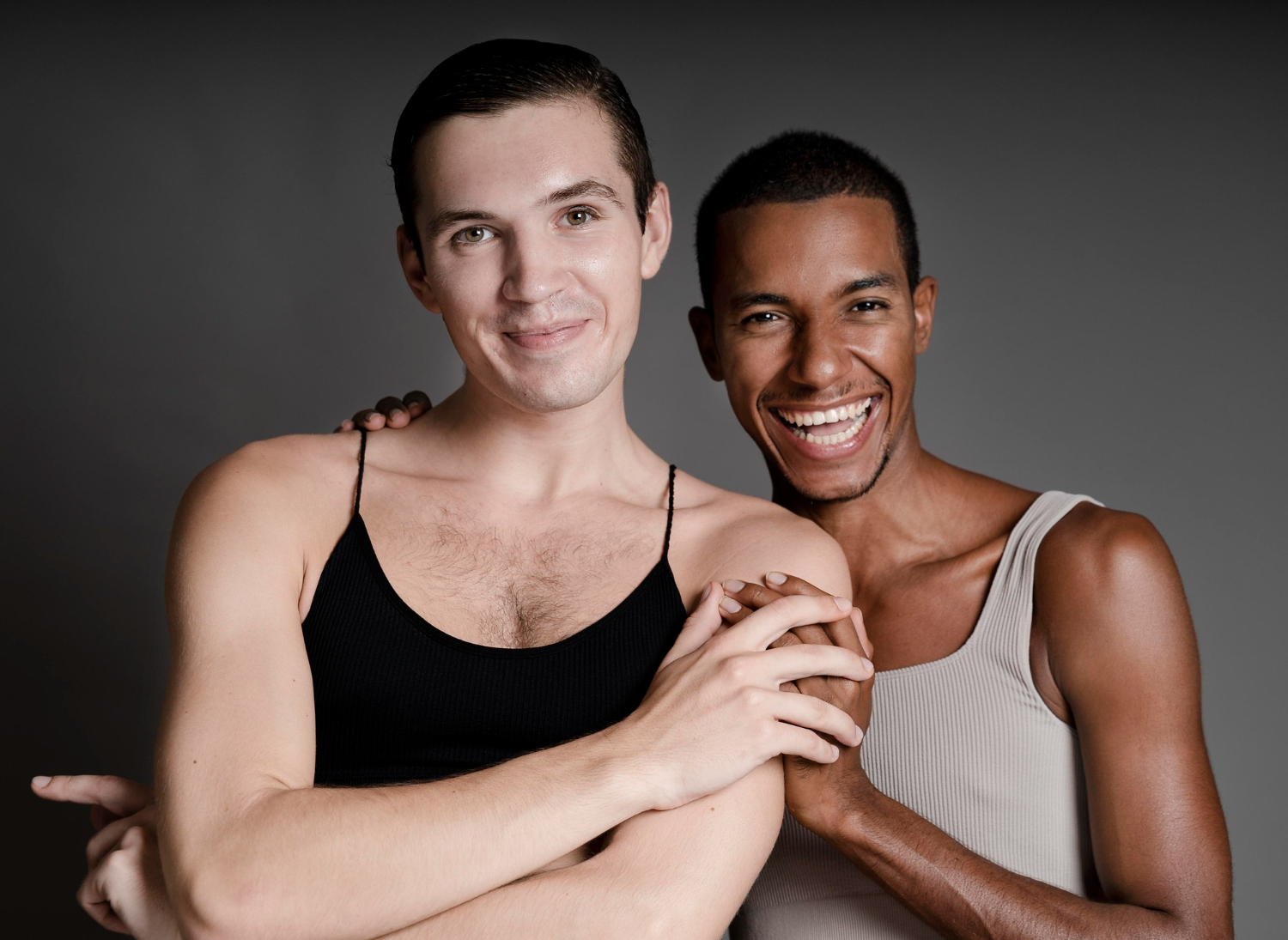 Two men smiling together in a studio setting