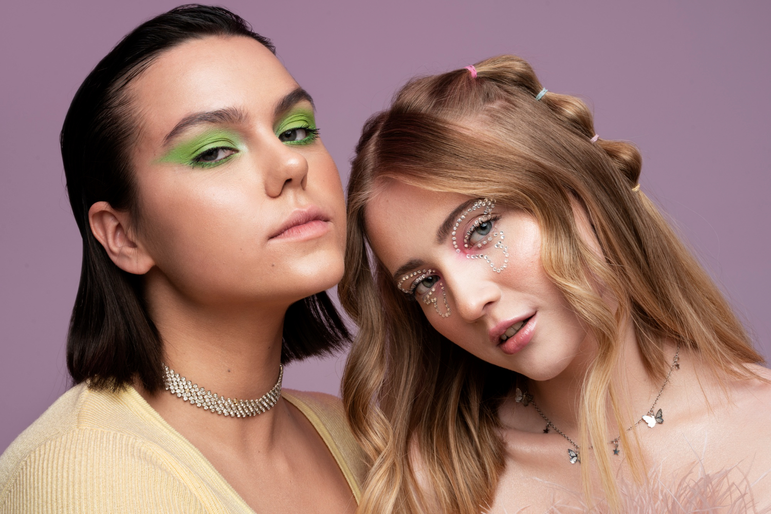 Two women sharing a close moment against a lavender background